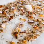 A large number of house cockroaches and insects are stuck on a glue trap, which is covered with both live and dead roaches, small debris, and insect parts—an effective way to eliminate cockroach infestations.